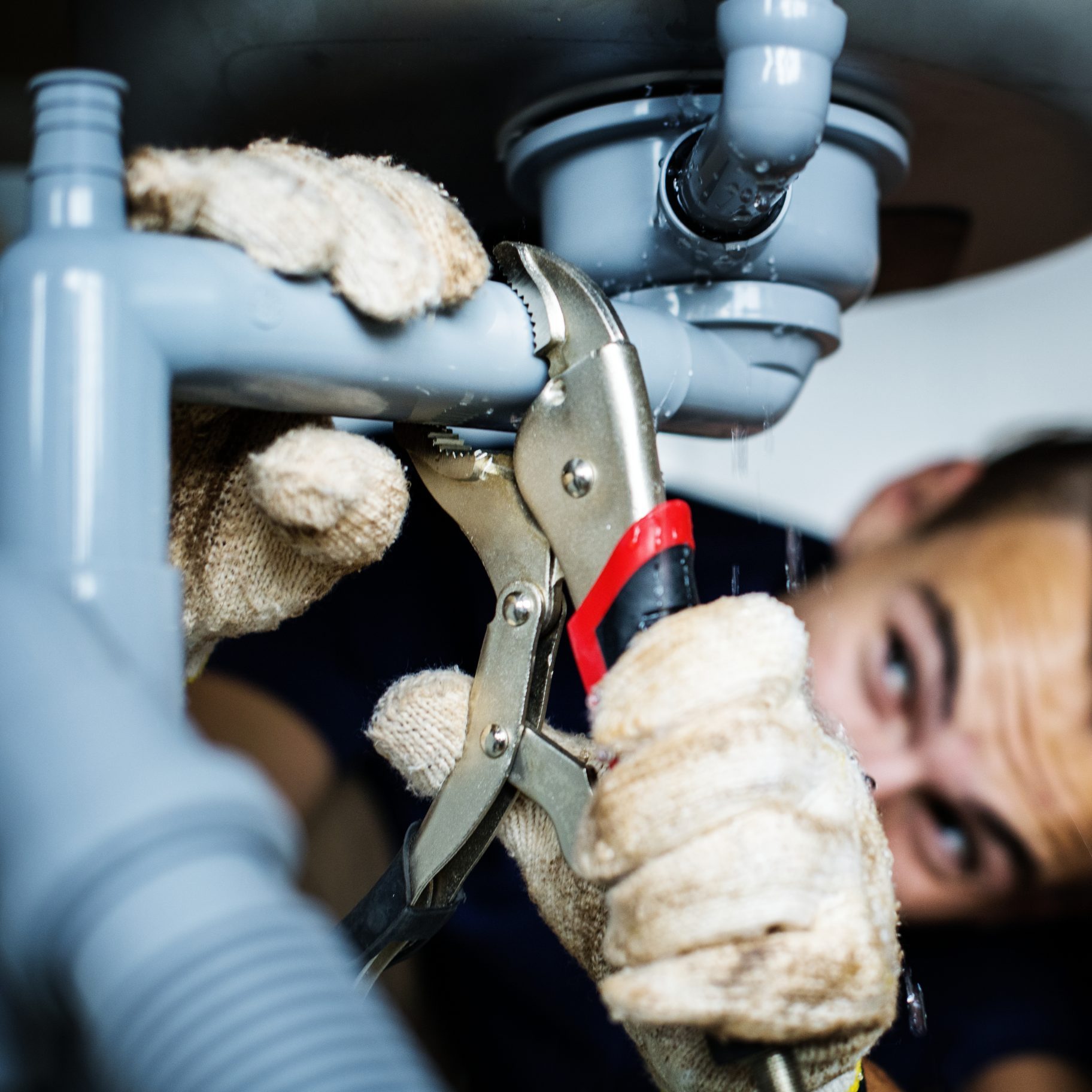 Man fixing kitchen sink Man fixing kitchen sink